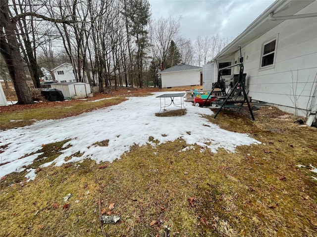 yard covered in snow with an outbuilding and a shed