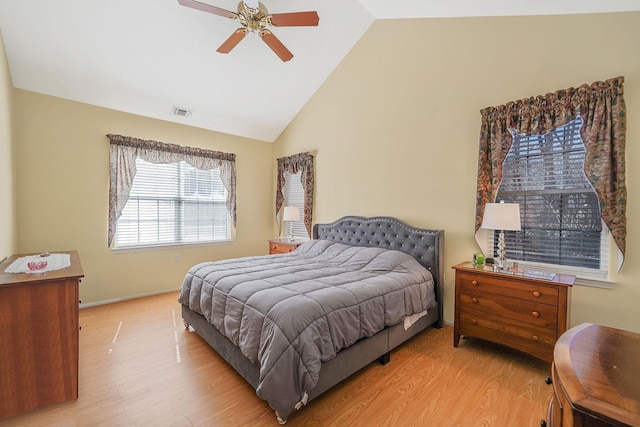 bedroom with vaulted ceiling, wood finished floors, visible vents, and baseboards