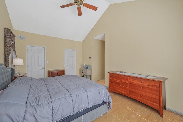 bedroom with light wood-style floors, visible vents, ceiling fan, and high vaulted ceiling