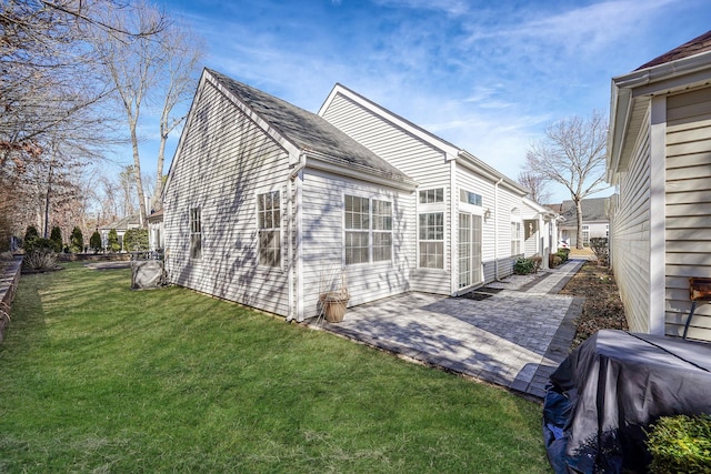 view of side of home featuring a lawn and a patio