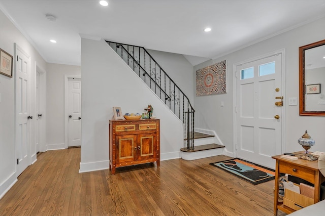 foyer featuring stairs, baseboards, wood finished floors, and recessed lighting