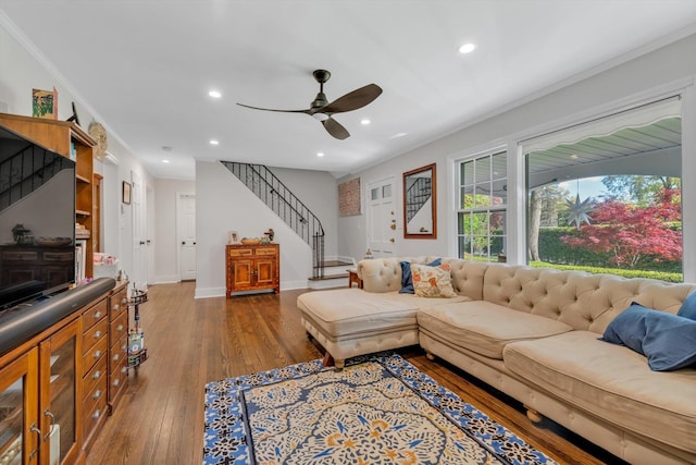 living area featuring baseboards, hardwood / wood-style flooring, stairs, crown molding, and recessed lighting