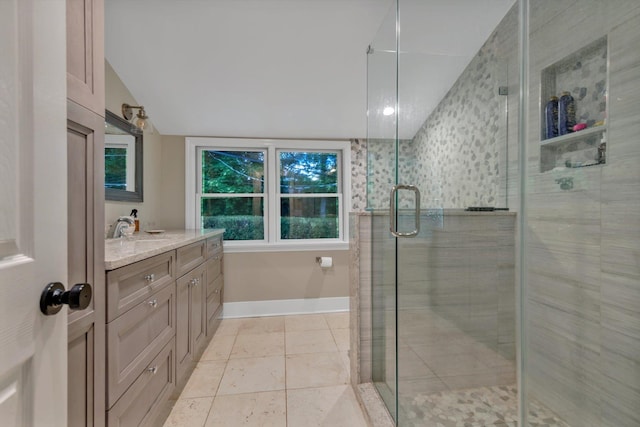 bathroom featuring a stall shower, tile patterned flooring, baseboards, and vanity