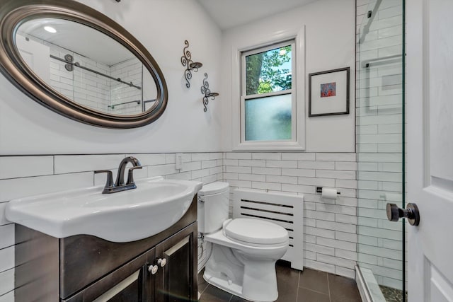 bathroom with wainscoting, toilet, tile patterned floors, vanity, and tile walls