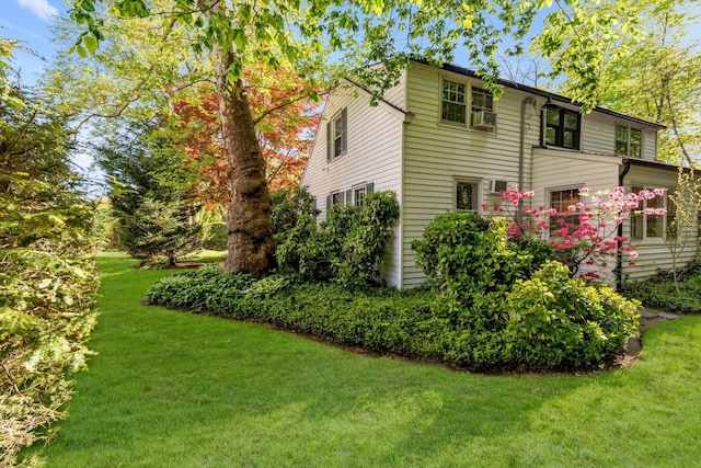 view of home's exterior featuring cooling unit and a yard