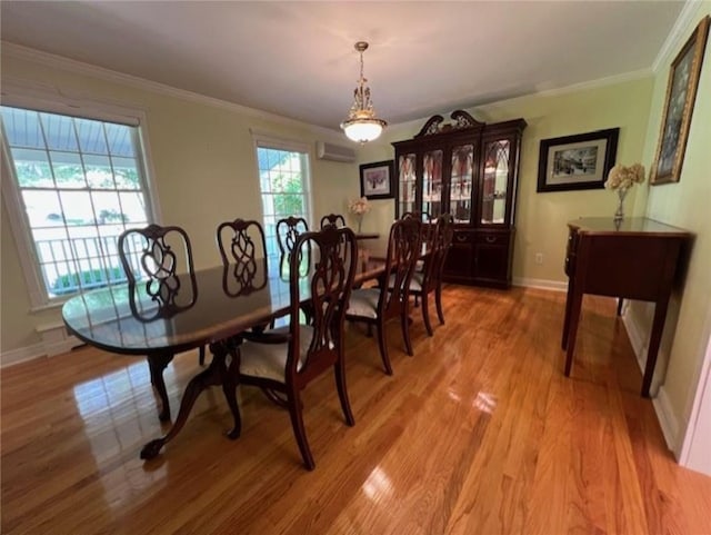 dining space featuring baseboards, a wall mounted air conditioner, crown molding, and light wood finished floors