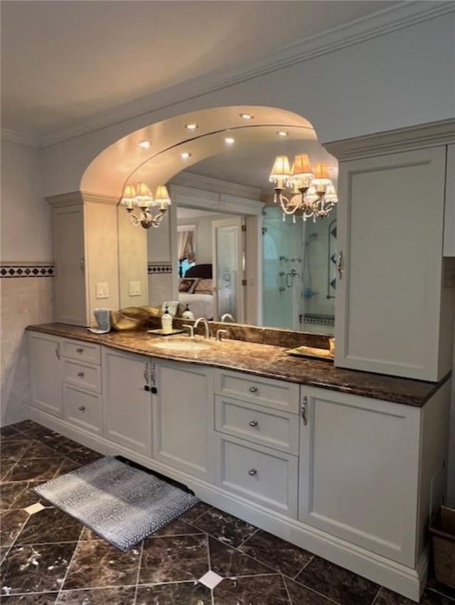 full bath featuring ornamental molding, marble finish floor, an enclosed shower, vanity, and a notable chandelier