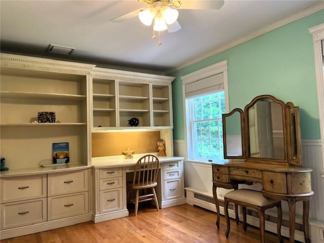 office area with a wainscoted wall, a baseboard radiator, crown molding, light wood-type flooring, and built in desk