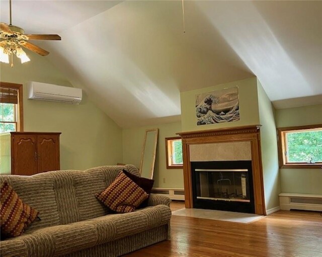 living room with lofted ceiling, a healthy amount of sunlight, an AC wall unit, and wood finished floors