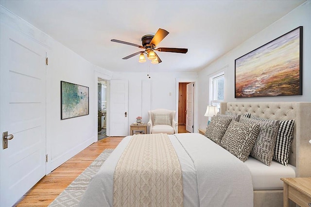 bedroom featuring ceiling fan, light wood-style flooring, and baseboards