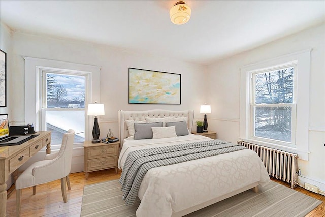 bedroom featuring wood finished floors and radiator