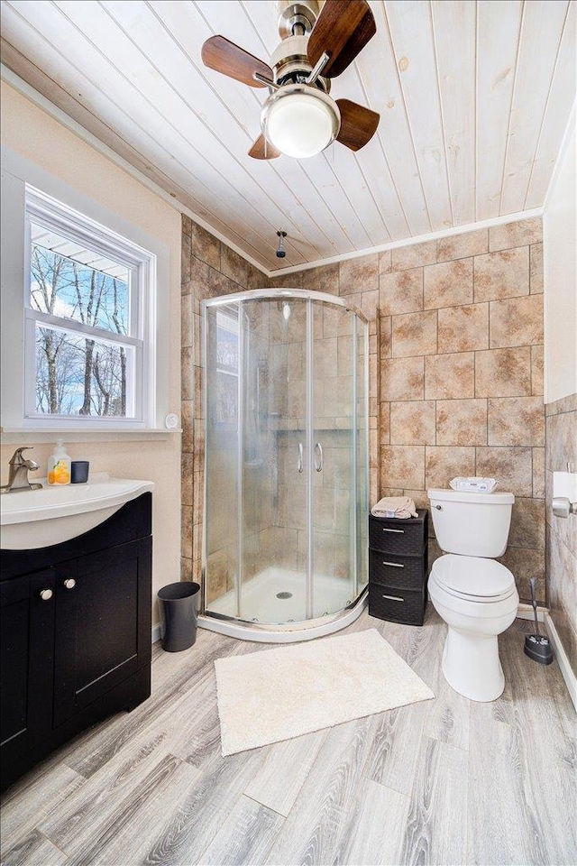 full bathroom with a stall shower, toilet, wooden ceiling, wood finished floors, and a sink