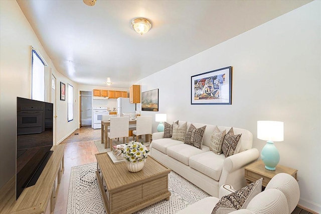 living area featuring light wood finished floors and baseboards