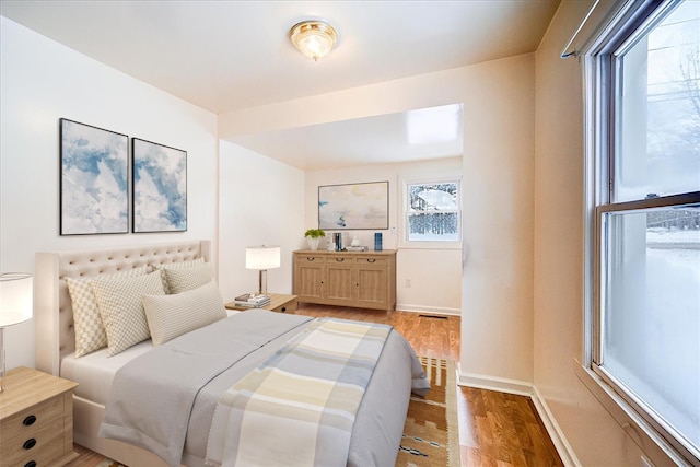 bedroom featuring light wood-style floors and baseboards