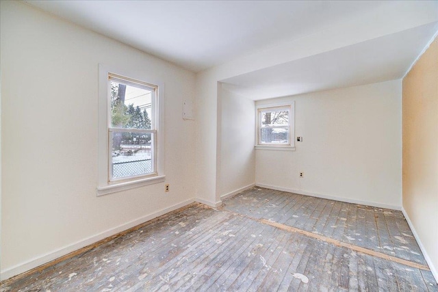 unfurnished room featuring baseboards and hardwood / wood-style flooring