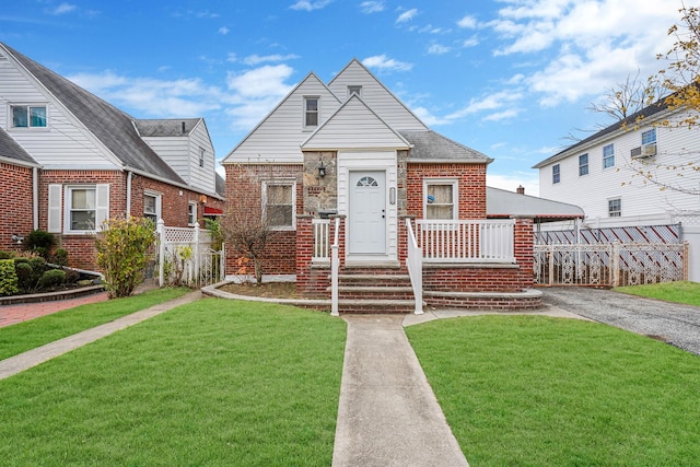 bungalow-style house featuring a front yard, fence, a porch, and brick siding