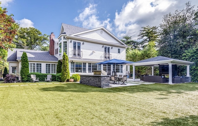 back of house featuring outdoor lounge area, a gazebo, a lawn, a chimney, and a patio area