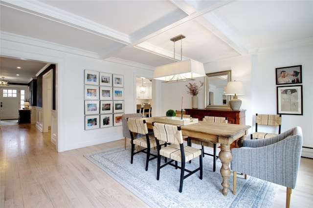 dining area with light wood-style flooring, crown molding, coffered ceiling, and beam ceiling