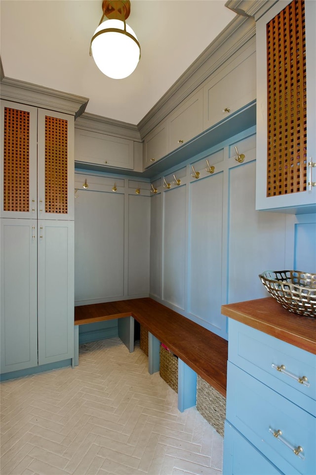 mudroom featuring crown molding and a decorative wall