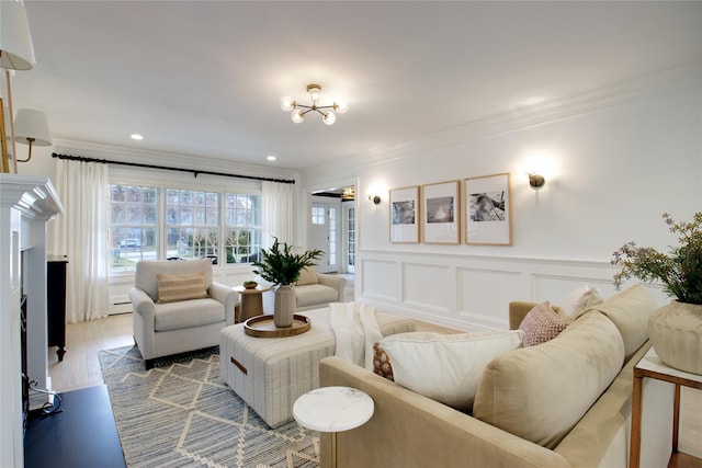 living area with crown molding, recessed lighting, a decorative wall, baseboard heating, and wood finished floors