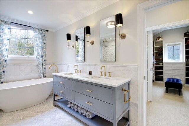 bathroom with double vanity, a wainscoted wall, crown molding, and a sink