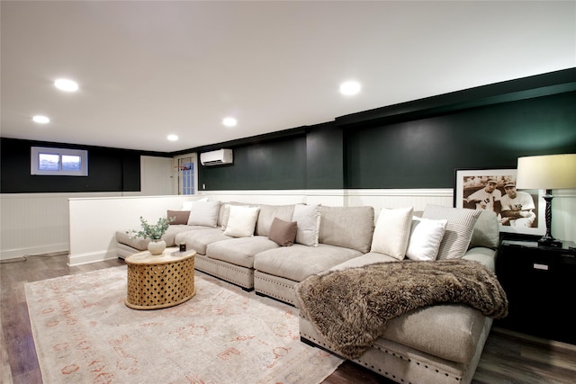 living area with a wainscoted wall, an AC wall unit, wood finished floors, and recessed lighting