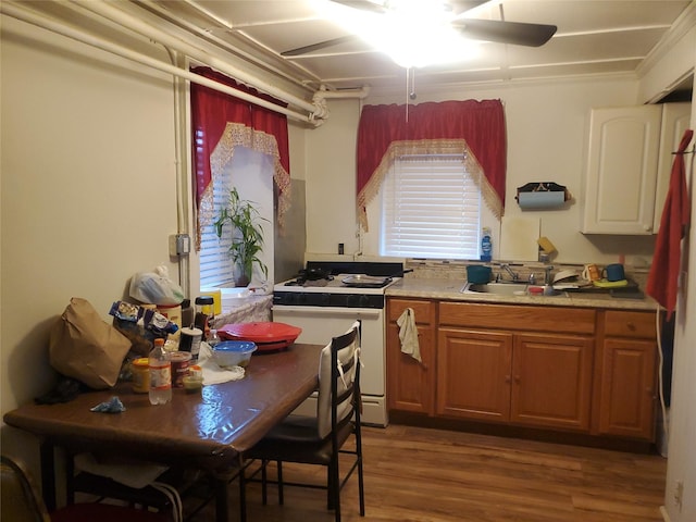 15 Roberts St, Middletown, NY 10940 - kitchen featuring white gas range oven, light countertops, a sink, wood finished floors, and brown cabinets
