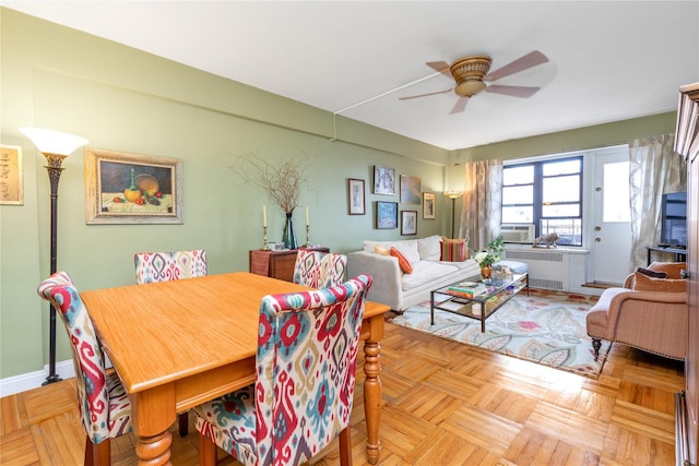 dining area featuring radiator heating unit, cooling unit, a ceiling fan, and baseboards