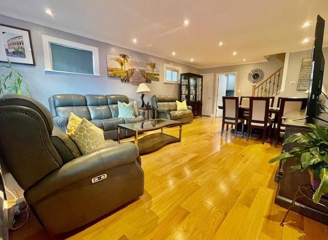 living area with light wood finished floors, stairs, ornamental molding, and recessed lighting