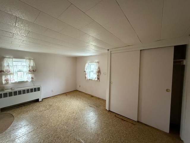 unfurnished bedroom with radiator and light floors