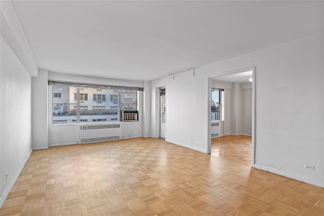 empty room featuring baseboards and radiator