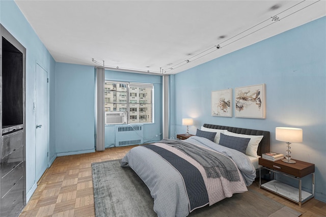 bedroom featuring cooling unit, radiator, and rail lighting