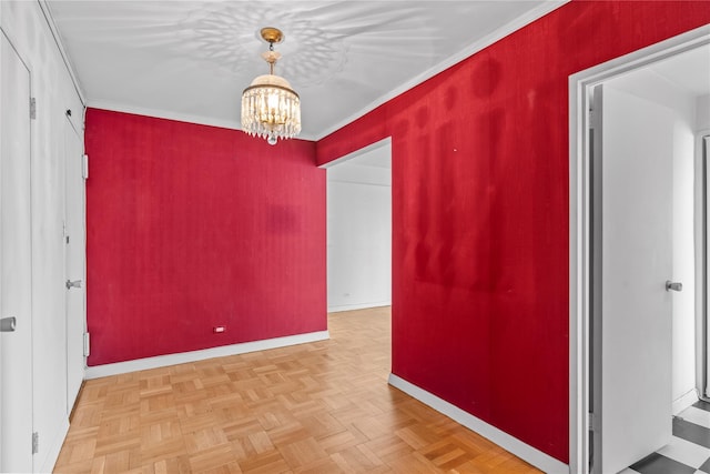 spare room featuring a notable chandelier, baseboards, and ornamental molding