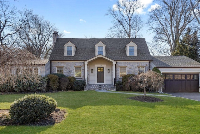 cape cod-style house featuring driveway, stone siding, roof with shingles, a front yard, and a garage