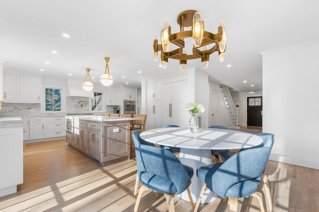 dining room featuring stairway, light wood-style flooring, recessed lighting, and a chandelier