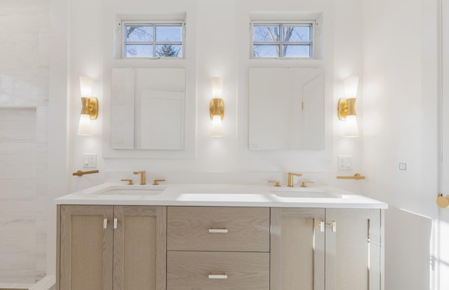 full bathroom with a sink, tiled shower, and double vanity