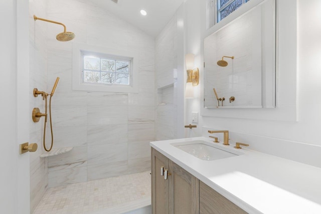 full bath with a tile shower, recessed lighting, vanity, and vaulted ceiling