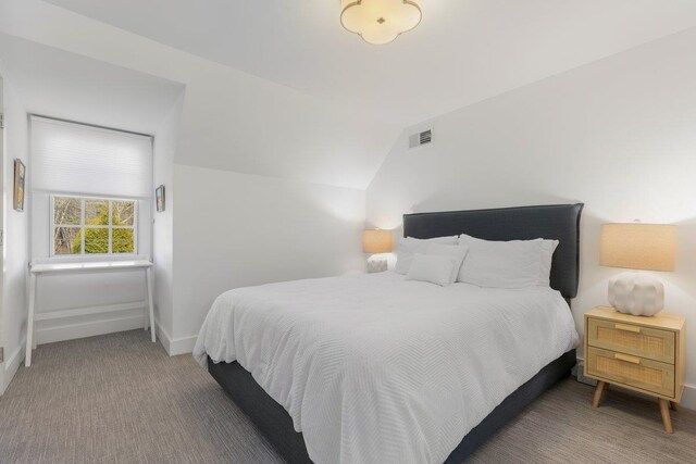 bedroom featuring baseboards, visible vents, lofted ceiling, and carpet floors