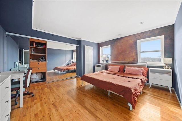 bedroom featuring light wood-style floors and crown molding