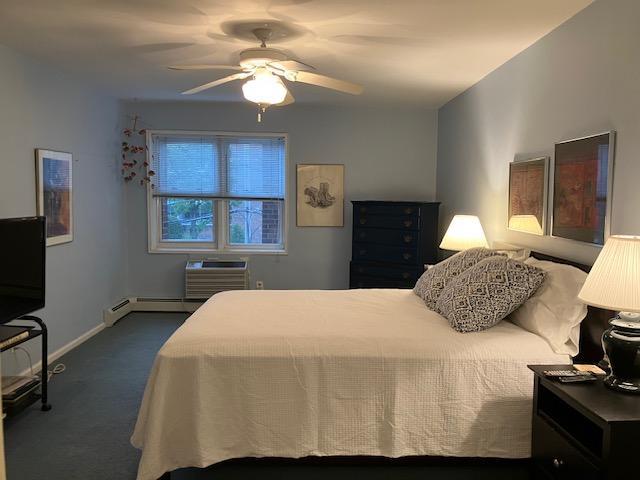 20 Chapel Pl Unit 2K, Great Neck, NY 11021 - carpeted bedroom featuring ceiling fan and a wall mounted air conditioner
