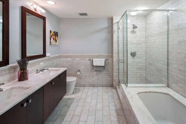 bathroom featuring a garden tub, a sink, visible vents, and a shower stall