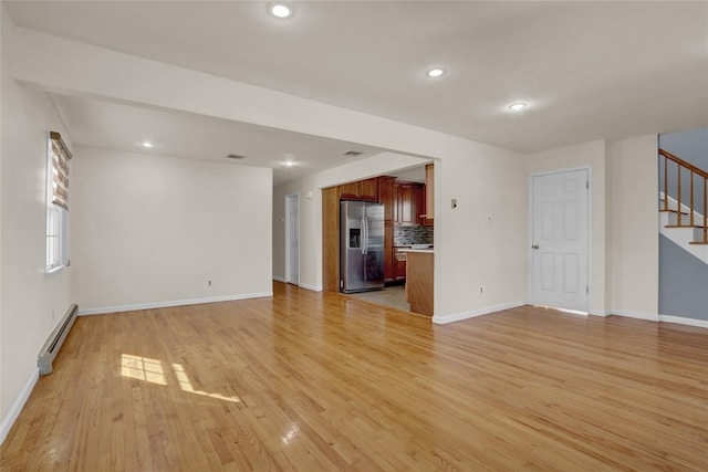 unfurnished living room with recessed lighting, a baseboard heating unit, baseboards, stairs, and light wood finished floors