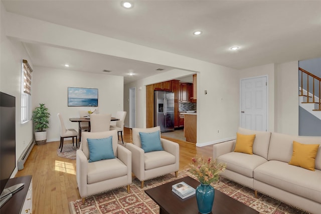 living room featuring light wood-style flooring, recessed lighting, baseboards, stairway, and baseboard heating