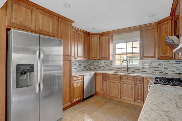 kitchen with stainless steel appliances, light countertops, a sink, and decorative backsplash