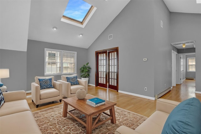 living room with a skylight, light wood finished floors, a baseboard radiator, visible vents, and baseboards