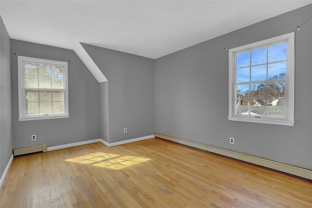 additional living space featuring a baseboard radiator, baseboards, and hardwood / wood-style floors