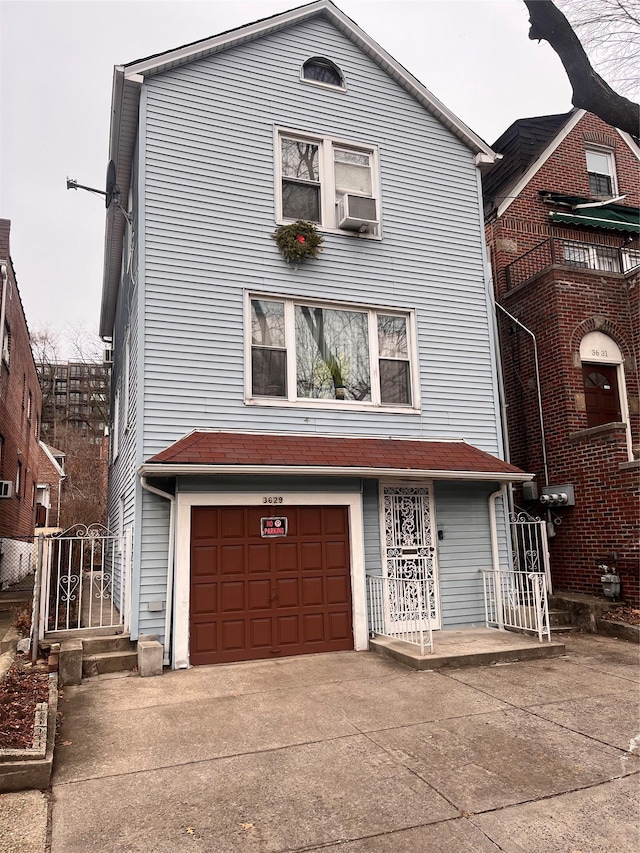 view of front of house featuring cooling unit, concrete driveway, and a garage