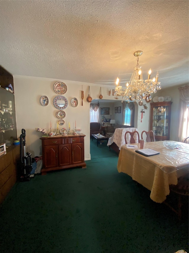 dining room featuring a textured ceiling, a chandelier, and dark carpet