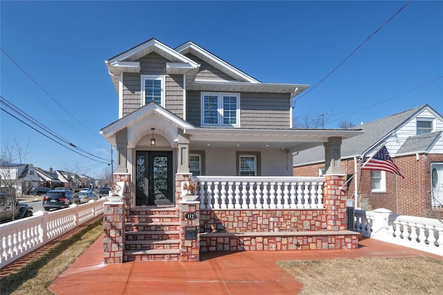 view of front facade featuring a porch, fence, and stucco siding