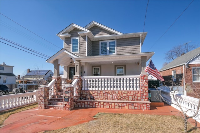 view of front of house featuring a porch, fence, and stucco siding